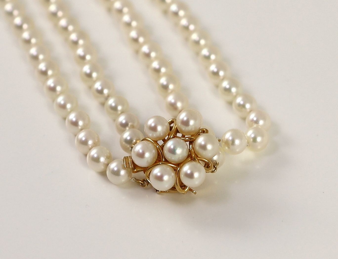 A modern continental double strand cultured pearl necklace with 14k gold and cultured pearl cluster set clasp and a matching bracelet